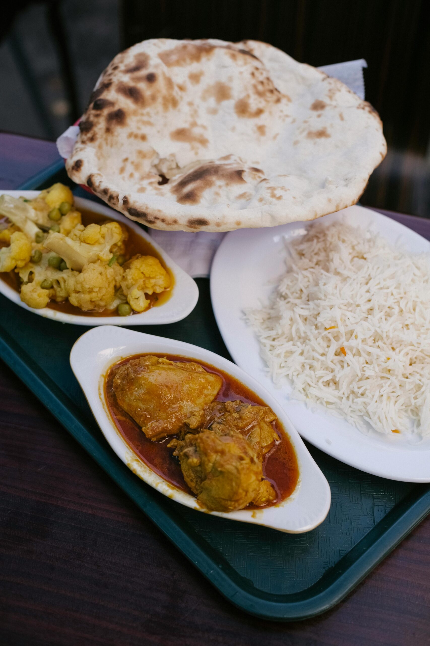 Delicious Indian meal featuring curry, naan bread, rice, and vegetables, perfect for lunch or dinner.