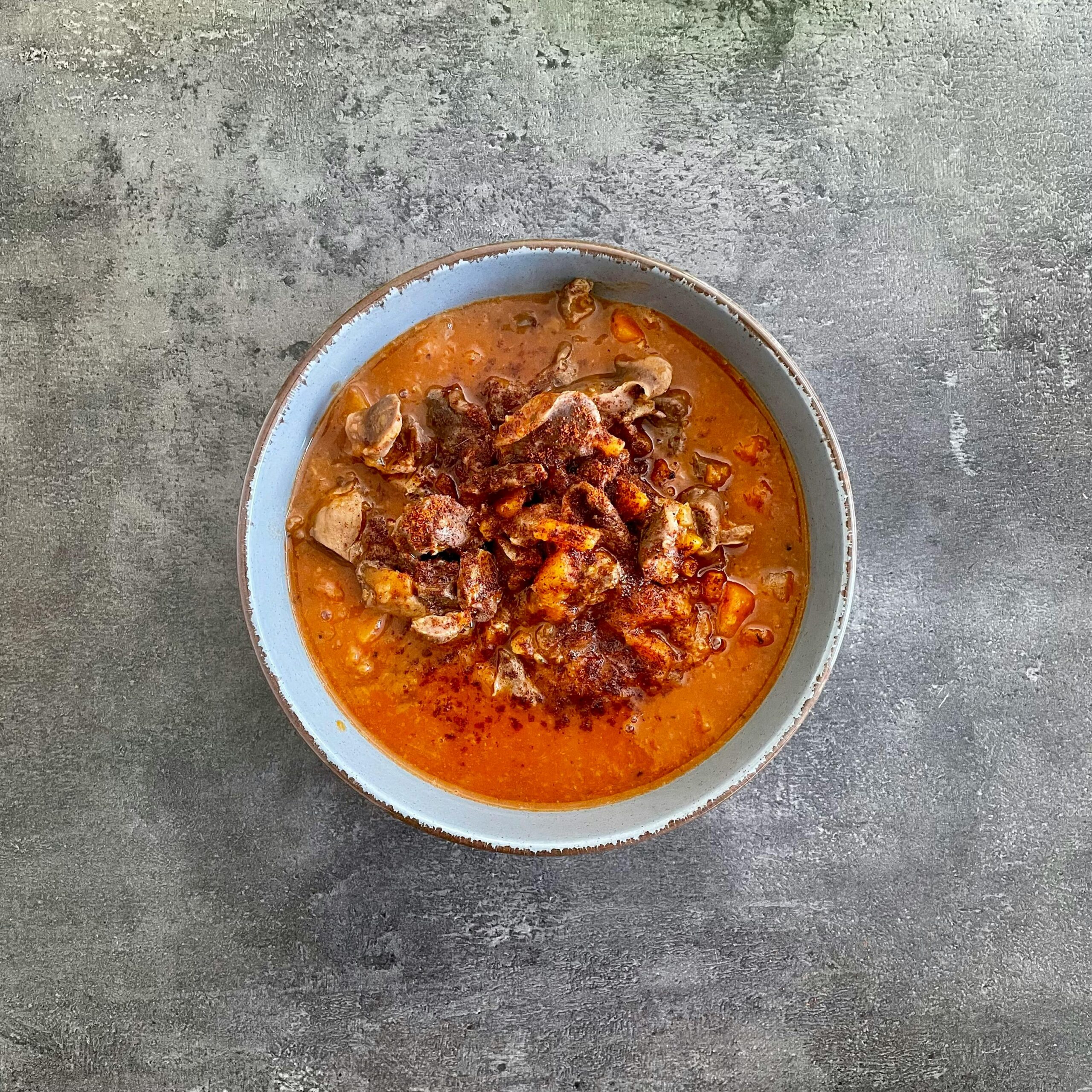 Delicious beef stew with rich spices in a bowl against rustic background.